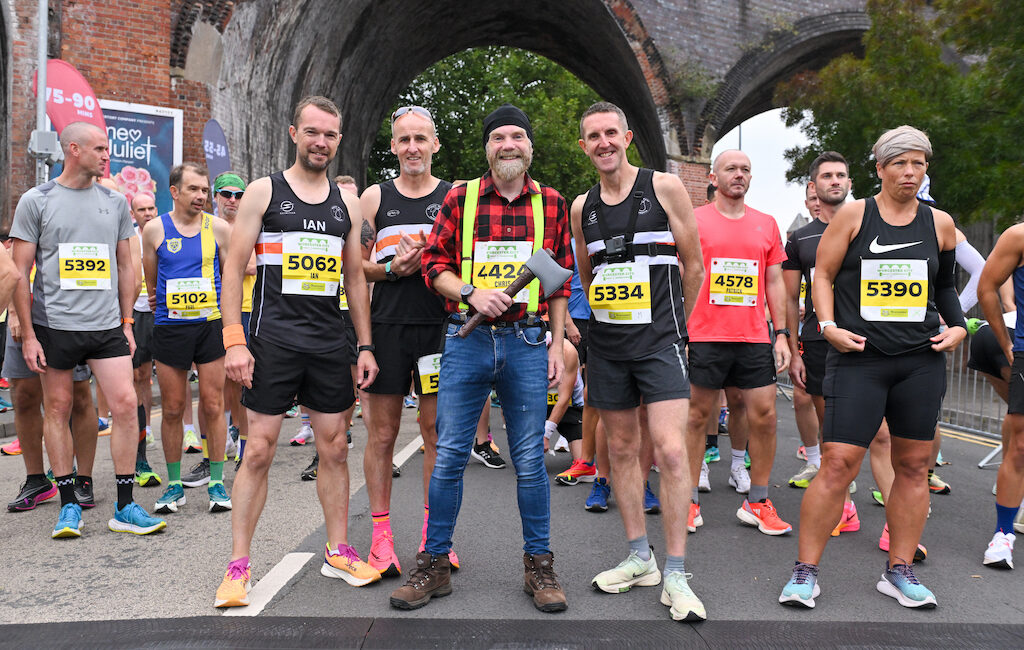 Chris Garratt dressed as a lumberjack, with three other runners on the start line of Worcester City Runs Half Marathon.